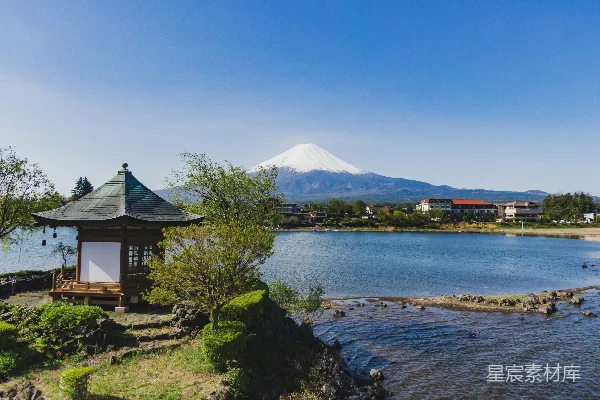 高清摄影 棕色和白色的房屋靠近湖和山，在蓝天下的白天景色是蓝色的。