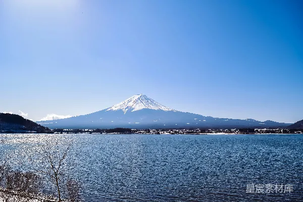 高清摄影 一片被蓝天下雪山环绕的湖泊，四周覆着白雪。