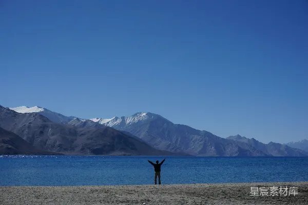 高清摄影 海边一个人站在那里，双臂高举空中
