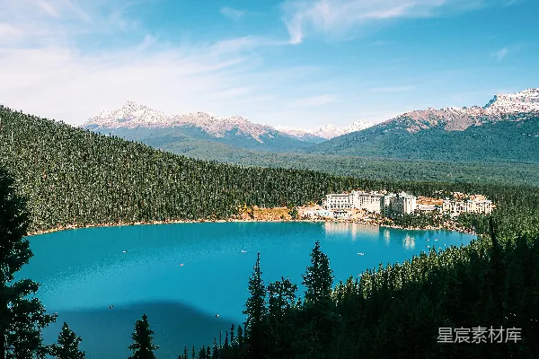 高清摄影 turquoise湖周围环绕着松树和山峦。