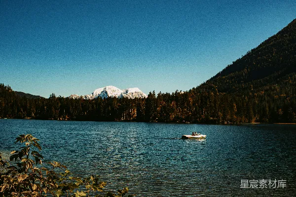 高清摄影 一艘船漂浮在被山脉环绕的湖上