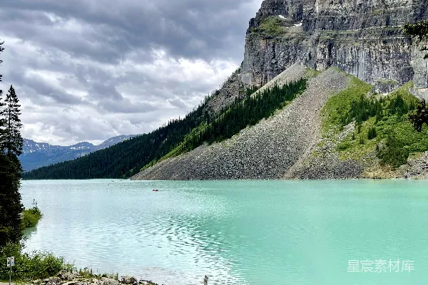 高清摄影 一片有岩石海岸线且背景为山体的水域