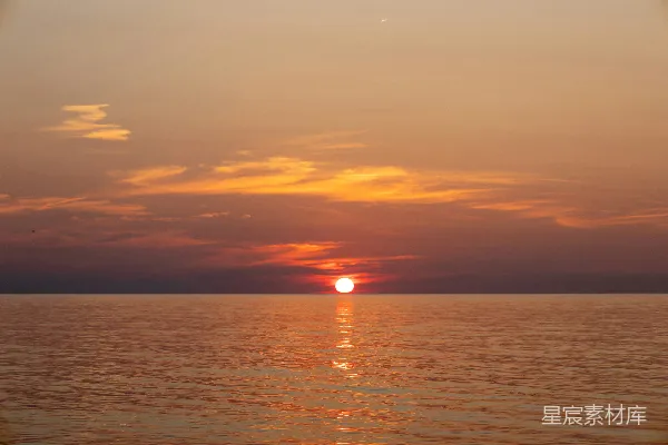 高清摄影 阴天时太阳正沉落在海洋之上。