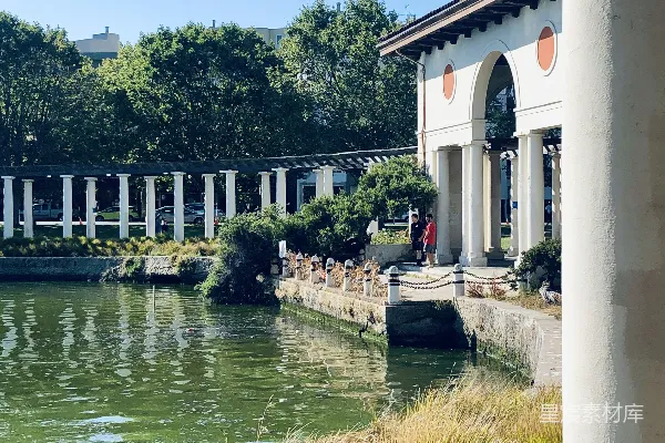 高清摄影 白天近河边的一栋白色和棕色混凝土建筑。