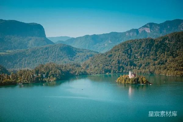 高清摄影 一个位于湖中的小岛，周围被山脉环绕。
