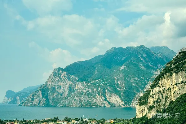 高清摄影 绿油油的田野和湖畔不远处的一座山脚下的小村庄。