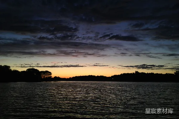 高清摄影 夕阳西下，映照在一片水域之上。
