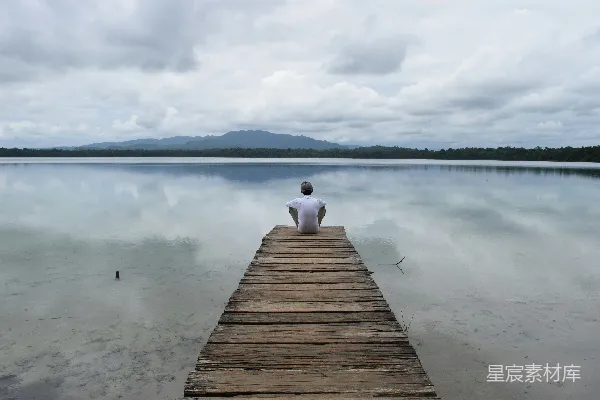 高清摄影 白天一个人坐在木制码头上欣赏湖景