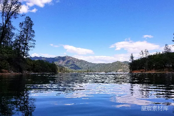 高清摄影 湖边有树木和山峰作为背景。