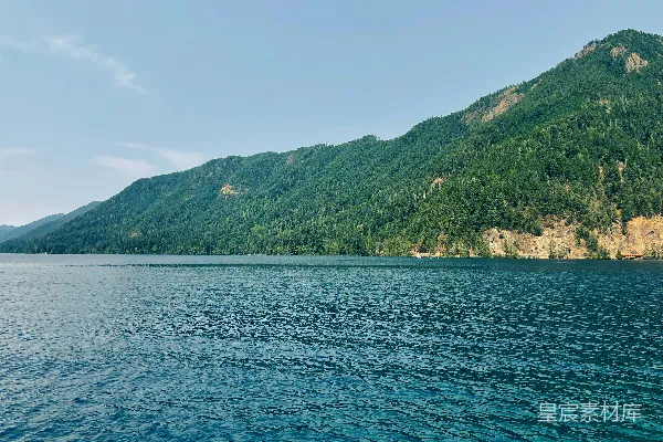 高清摄影 山间绿意正浓，白天景色映衬于水面之上。