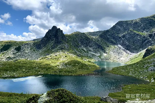 高清摄影 绿色和灰色的山靠近湖，在白云蓝天下的白天景色