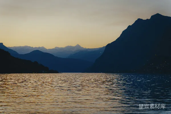 高清摄影 山峰在夕阳下的平静水面中映照。