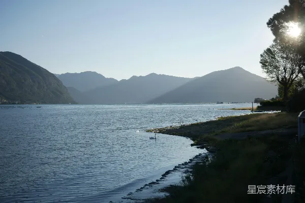 高清摄影 周围环绕着草地和山丘的一片水域