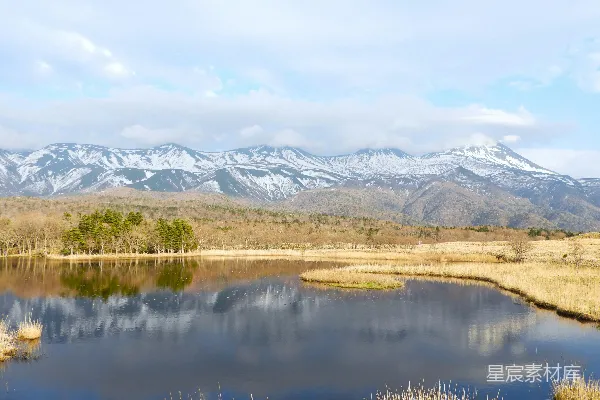 高清摄影 一个被田野环绕的湖泊，背景是山脉。