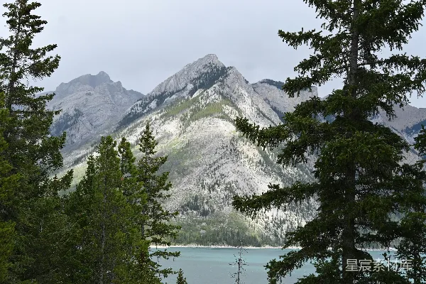 高清摄影 山脚下一片山峦景色，湖水在前景中显现。