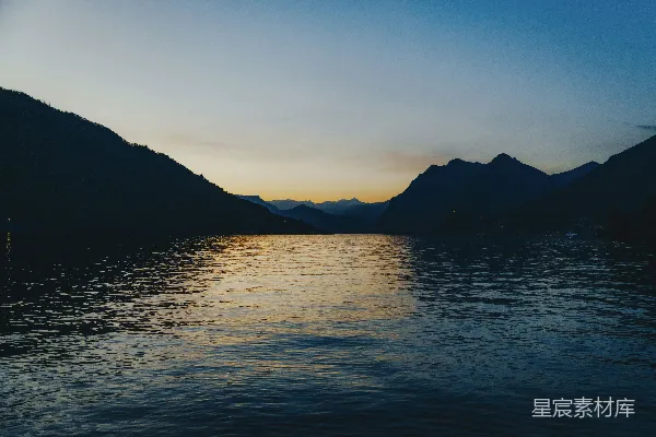 高清摄影 夕阳下山峦环绕着一片静湖。