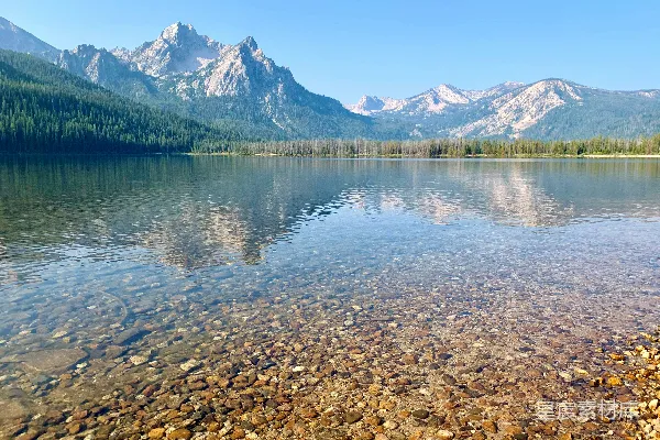 高清摄影 一个被山环绕的湖泊，湖中有岩石