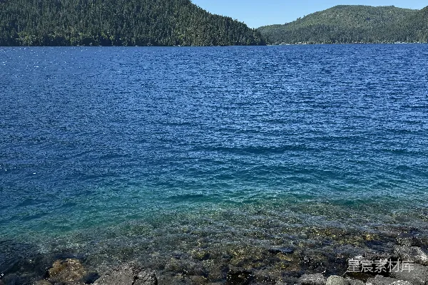高清摄影 一片蓝色的湖泊映照着晴朗的天空和山峦。