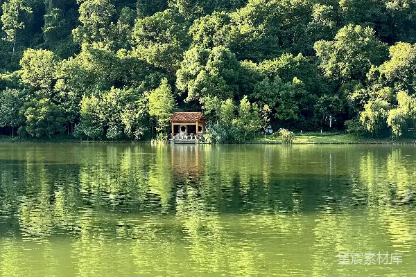 高清摄影 山坡上有一栋房子，靠近湖边，周围有树木。