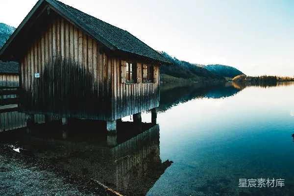 高清摄影 木头搭建的棕色小屋坐落在水上。