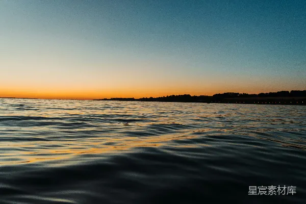 高清摄影 背景中有夕阳的一片水域。