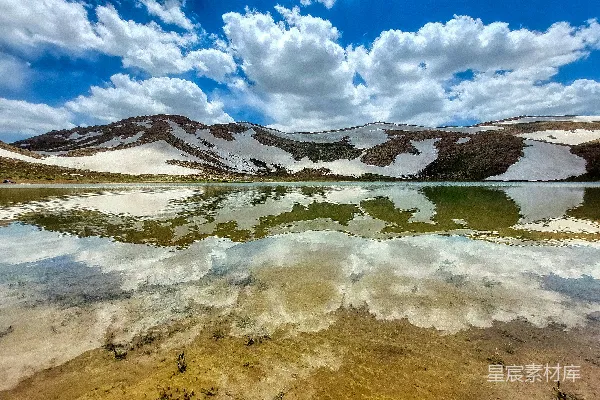 高清摄影 一片被蓝天下雪山环绕的湖泊，湖面覆盖着皑皑白雪。
