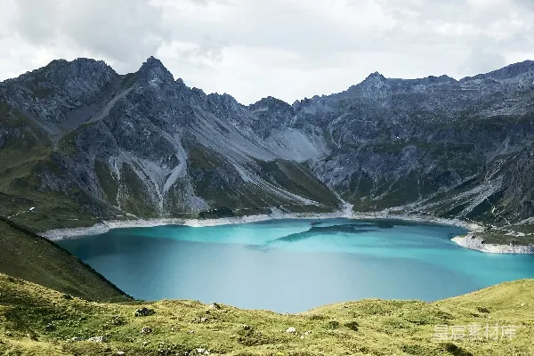 高清摄影 蓝湖周围环绕着山峦，在一片乌云密布的天空下。