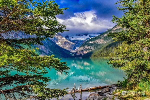 高清摄影 一片被树木和山峦环绕的湖泊，在阴云密布的天空下。