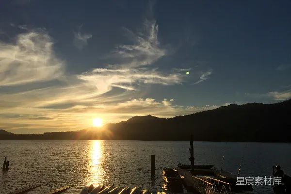 高清摄影 湖面平静下的夕阳美景，山峦在背景中衬托。