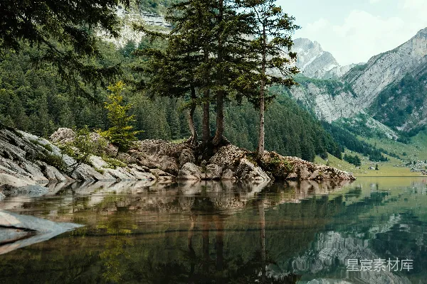 高清摄影 湖边有树木和山峰作为背景。