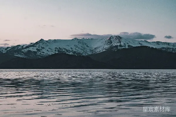 高清摄影 白天山体附近覆盖着积雪的山脉靠近一个水体