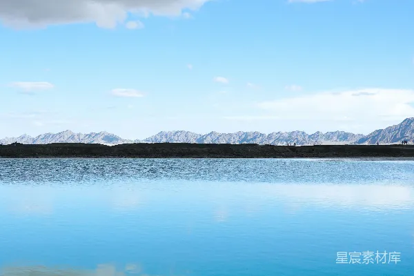 高清摄影 白天湖畔雪覆盖的山峦下，蓝天中