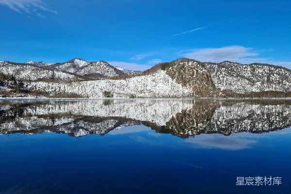 高清摄影 一片被雪山环绕的湖泊在蓝天之下静卧。