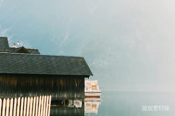 高清摄影 湖边的一座小木屋，背景是山峦。