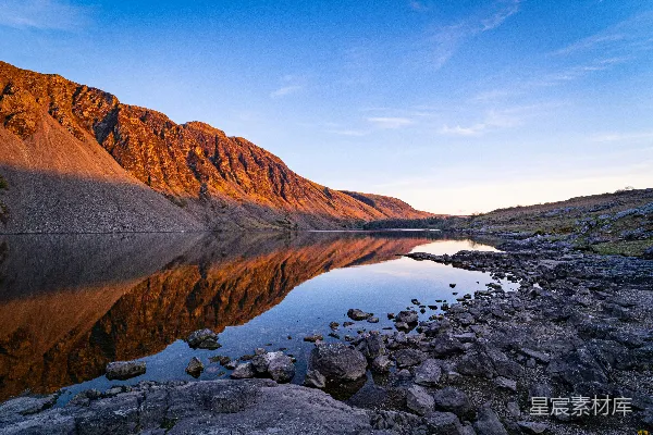 高清摄影 棕色山附近有一片水域，在蓝天的映衬下在白天景象中