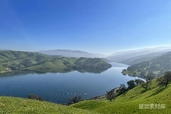 高清摄影 一片广阔的水域被郁郁葱葱的绿 hills 围绕着