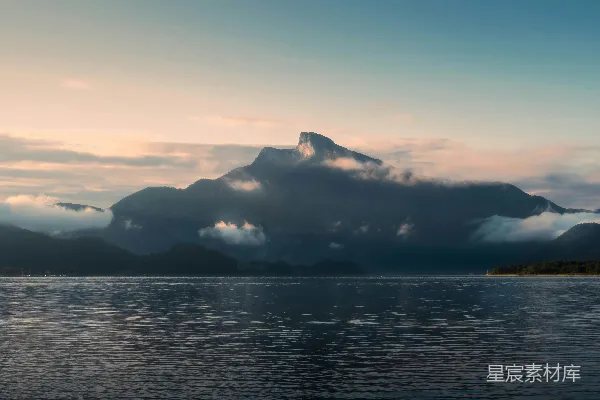高清摄影 晨雾山脉在一片平静的湖面上拔地而起。
