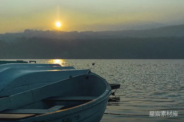 高清摄影 夕阳下白色的蓝色小船在海上。