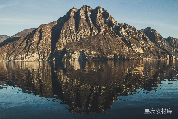 高清摄影 棕色山位于水体之上