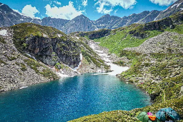 高清摄影 蓝湖周围被山脉和草地环绕