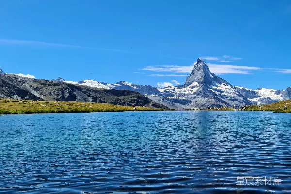高清摄影 白天山顶附近有一片雪覆盖的山体靠近水面