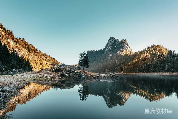 高清摄影 湖边有树木和山峰作为背景。