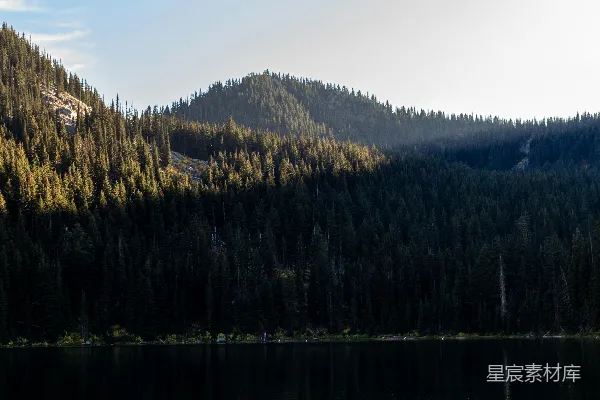 高清摄影 湖畔有树木和山峰作为背景。