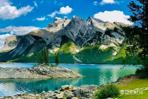 高清摄影 湖边有绿树和山，在蓝天的照耀下白天景色宜人。