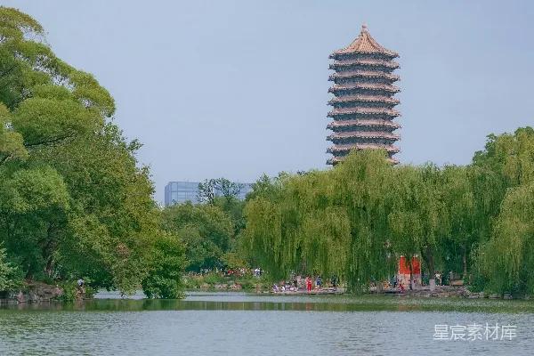 高清摄影 一座高塔矗立在被树木环绕的湖边。