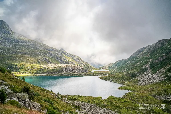 高清摄影 一片宁静的山间湖泊，周围环绕着岩石和绿色山坡。