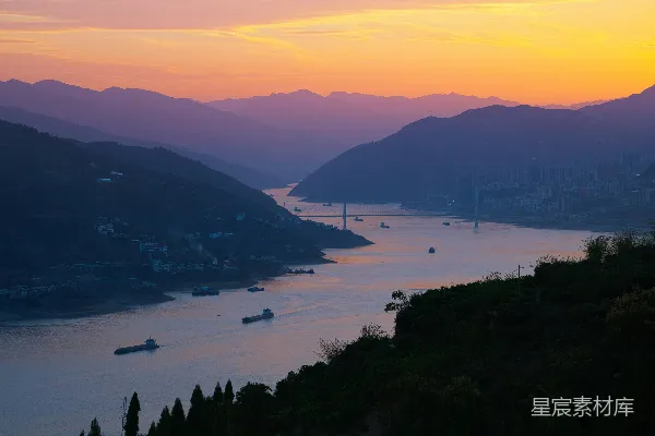 高清摄影 夕阳下的水面景色，背景是群山。