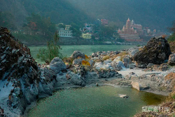 高清摄影 湖边有建筑，山峦在背景中。