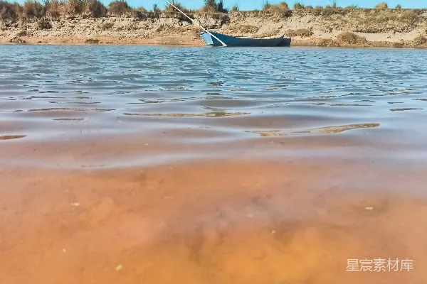 高清摄影 湖边沙滩旁漂浮着一艘小船。