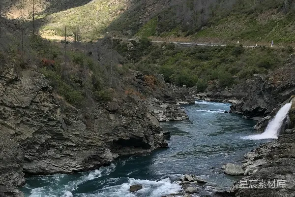 高清摄影 一条河流穿过一片翠绿的山坡